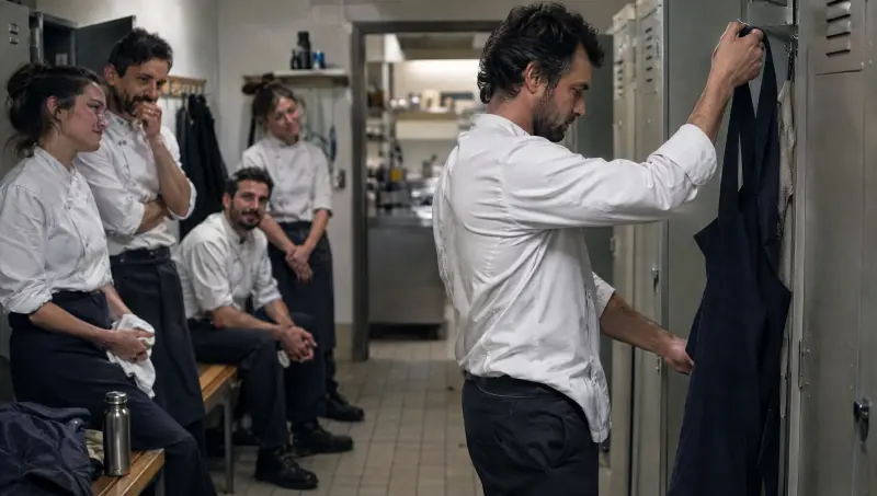 Un cuisinier raccroche son tablier pour la dernière fois, ses collègues lui disent au revoir